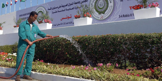 TUNIS, TUNISIA: A municipal employee waters 19 May 2004 the flowers in front of the Congress Palace of Tunis, three days before the beginning of the Arab League Summit 16th ordinary session. AFP PHOTO/FETHI BELAID (Photo credit should read FETHI BELAID/AFP/Getty Images)