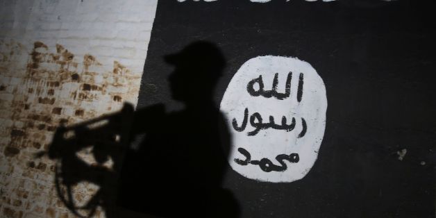 TOPSHOT - A member of the Iraqi forces walks past a mural bearing the logo of the Islamic State (IS) group in a tunnel that was reportedly used as a training centre by the jihadists, on March 1, 2017, in the village of Albu Sayf, on the southern outskirts of Mosul.Iraqi forces launched a major push on February 19 to recapture the west of Mosul from the Islamic State jihadist group, retaking the airport and then advancing north. / AFP PHOTO / AHMAD AL-RUBAYE (Photo credit should read AHMAD
