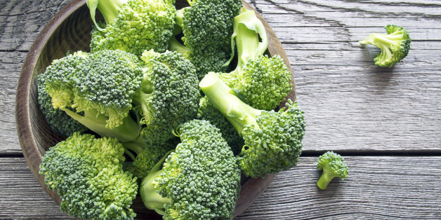 Raw broccoli in a bowl on rustic background