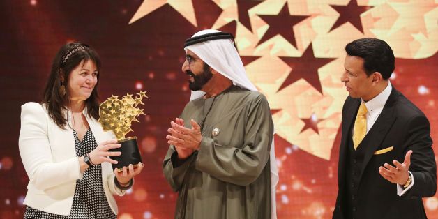 Canadian teacher Maggie MacDonnell (L) receives the Global Teacher Prize from Sheikh Mohammed bin Rashid al-Maktoum (C), vice-president and Prime Minister of the UAE and Ruler of Dubai, during a ceremony in Dubai on March 19, 2017.MacDonnell, who works in a fly-in only village in the Arctic, was among 10 finalists chosen from 179 countries and won a $1 million prize. / AFP PHOTO / KARIM SAHIB (Photo credit should read KARIM SAHIB/AFP/Getty Images)