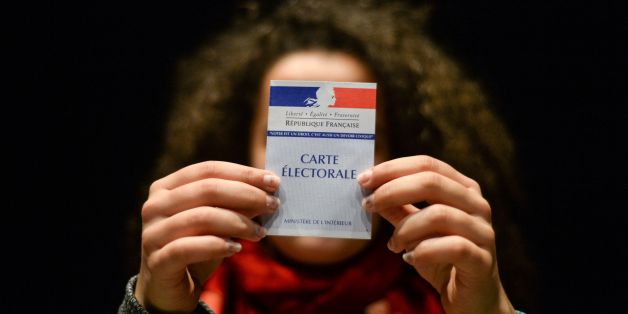 A woman holds her first electoral card, on March 19, 2017, in Besancon, eastern France. / AFP PHOTO / Sébastien BOZON (Photo credit should read SEBASTIEN BOZON/AFP/Getty Images)