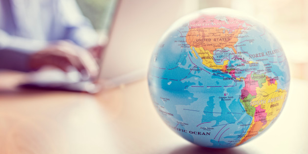 Businessman using a laptop with close up on world globe