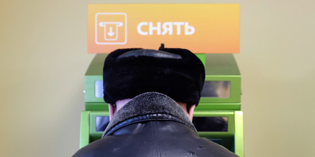 Ein Man hebt Geld von einem russischen Bankautomat ab
