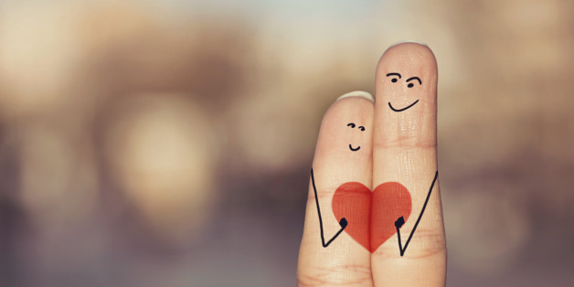 Happy loving fingers holding red heart