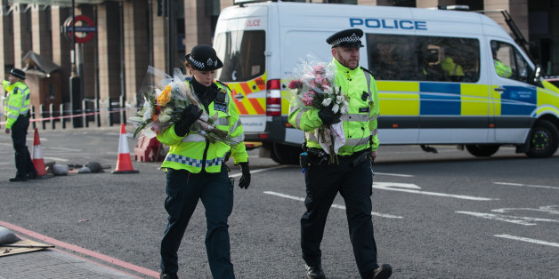 LONDON, ENGLAND - MARCH 23: Police officers arrive with floral tributes on Westminster Bridge following yesterday's attack in which one police officer was killed on March 23, 2017 in London, England. Four people have been killed and around 40 people injured following yesterday's attack by the Houses of Parliament in Westminster. (Photo by Jack Taylor/Getty Images)