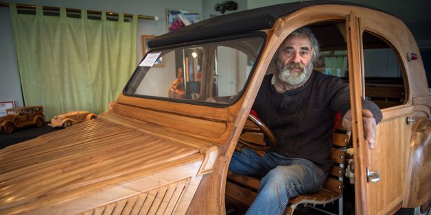 French cabinetmaker Michel Robillard poses in his handbuilt wooden 2CV Citroen Car built as an exact one/one replica on March 20, 2017, near Loches, Central France. A retired cabinetmaker has just completed the production of a Citroen 2 CV in a Touraine fruitwood, a life-size vehicle unique in the world, equipped to take the road, which is about to pass its first technical inspection. / AFP PHOTO / GUILLAUME SOUVANT (Photo credit should read GUILLAUME SOUVANT/AFP/Getty Images)