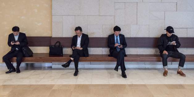 People look at their mobile phones at a mall in the Gangnam district of Seoul on October 11, 2016.Samsung told customers worldwide to stop using their Galaxy Note 7 smartphones as it struggled to contain a snowballing safety crisis that threatens to derail the powerhouse global brand. / AFP / Ed Jones (Photo credit should read ED JONES/AFP/Getty Images)
