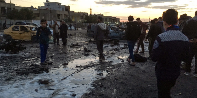 TOPSHOT - A picture taken with a mobile phone on February 16, 2017 shows locals looking through debris at the scene of a blast by a massive car bomb, which killed dozens in a used car market in southern Baghdad.
The Amaq propaganda agency linked to the Islamic State group (IS), which has claimed nearly all such attacks recently, reported the blast and described it as targeting 'a gathering of Shiites'. / AFP / Ahmad MOUSA (Photo credit should read AHMAD MOUSA/AFP/Getty Images)