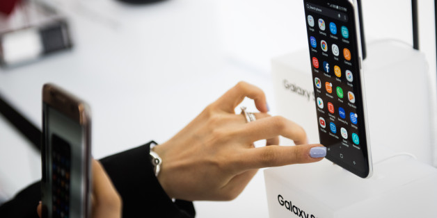 An attendee views the Samsung Electronics Co. Galaxy S8 smartphone displayed during the Samsung Unpacked product launch event in New York, U.S., on Wednesday, March 29, 2017. Samsung Electronics Co. packed the Galaxy S8 smartphone with a plethora of new features: taller, curved screens, encrypted facial recognition, deeper display colors, system-wide voice control and the ability to turn into a desktop computer. Photographer: Mark Kauzlarich/Bloomberg via Getty Images
