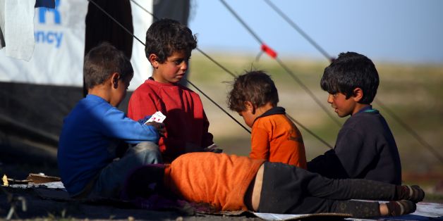 Syrian children play cards at a temporary refugee camp in the village of Ain Issa, housing people who fled Islamic State group's Syrian stronghold Raqa, some 50 kilometres (30 miles) north of the group's de facto capital on March 25, 2017. / AFP PHOTO / DELIL SOULEIMAN (Photo credit should read DELIL SOULEIMAN/AFP/Getty Images)