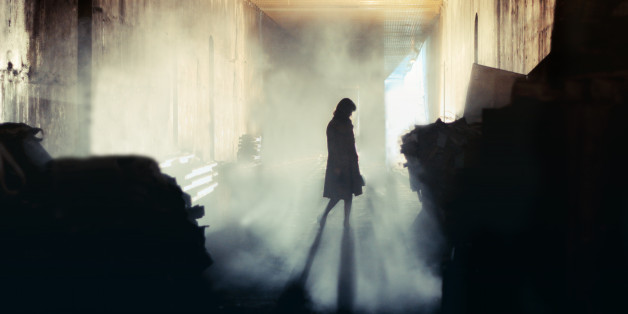 A lone wonan stands in a misty underground tunnel