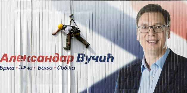 A worker installs on a wall an electoral poster of the Serbian Progressive Party (SNS) top candidate for the presidential election and Serbian Prime Minister Aleksandar Vucic in Belgrade on March 23, 2017.
Serbia's strongman Aleksandar Vucic hopes to win presidential elections in the first round on April2, 2017, to strengthen his political power despite criticism from divided opposition accusing him of authoritarianism. / AFP PHOTO / OLIVER BUNIC (Photo credit should read OLIVER BUNIC/AFP/Getty Images)