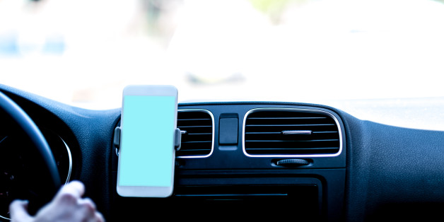 Driver using GPS to follow the route. Travelling with GPS. Uber application on smart phone in action.