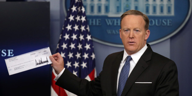 White House Press Secretary Sean Spicer shows a check from U.S. President Donald Trump's salary which will be donated to the National Park Service during a daily press briefing at the White House in Washington, U.S., April 3, 2017. REUTERS/Carlos Barria