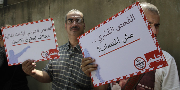 Lebanese demonstrators hold signs reading 'Tests to prove homosexuality are against human rights' (L) and 'Isn't a forced test considered rape?' during a protest in Beirut on August 11, 2012. Dozens of people demonstrated outside the law courts in the Lebanese capital to protest the use of anal 'tests' on men suspected of homosexuality, which is a criminal offence in the Arab country. The protest also voiced solidarity with women subjected to so-called 'virginity tests.' AFP PHOTO / ANWAR AMRO