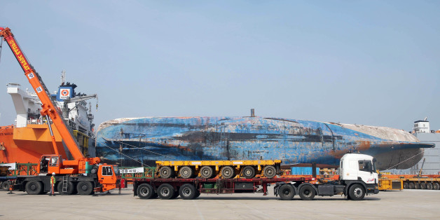A general view shows the wreck of the Sewol ferry as it arrives mounted on a semi-submersible barge at a port in Mokpo on March 31, 2017.The salvaged wreck of South Korea's Sewol ferry completed its final journey to shore, officials said, as investigators prepare to comb it for remains. A semi-submersible ship carrying the wreck left for the southwestern port of Mokpo, the maritime ministry said in a press statement. Nearly three years after it went down with the loss of more than 300 lives, the