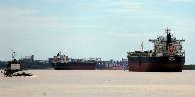 Ships used to carry grains for export are seen next to a dredging boat (L) on the Parana river near Rosario, Argentina, January 31, 2017. Picture taken January 31, 2017. REUTERS/Marcos Brindicci