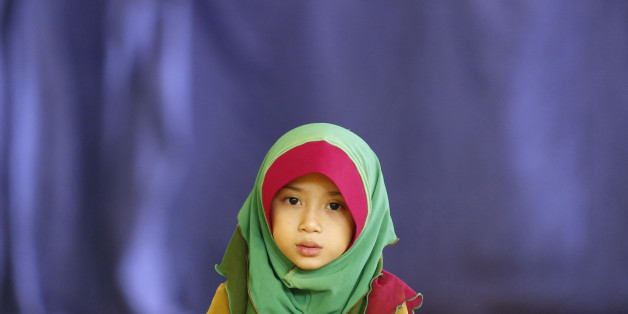 Young Malaysian Muslim, Aisyah Fatoni, 6, reads a prayer as she waits for her father performing Asr prayer during the month of Ramadan at a mosque in Kuala Lumpur July 15, 2013. Ramadan, which began last Wednesday in Muslim-majority Malaysia, is the holiest month of the Islamic calendar. REUTERS/Bazuki Muhammad (MALAYSIA - Tags: SOCIETY RELIGION)