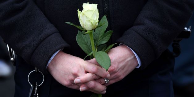 A police woman holds a white rose on Westminster Bridge in central London on March 29, 2017 during a vigil by faith leaders and the Metropolitan Police on the bridge to commemorate one-week since the March 22 terror attack that killed four. Four people were killed and scores more injured after British man Khalid Masood ploughed a speeding vehicle through a crowd of pedestrians and fatally stabbed a policeman just inside the gates of the British parliament before being shot dead himself in a fren