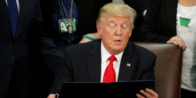 U.S. President Donald Trump reads an executive order before signing it at Homeland Security headquarters in Washington, U.S., January 25, 2017. REUTERS/Jonathan Ernst