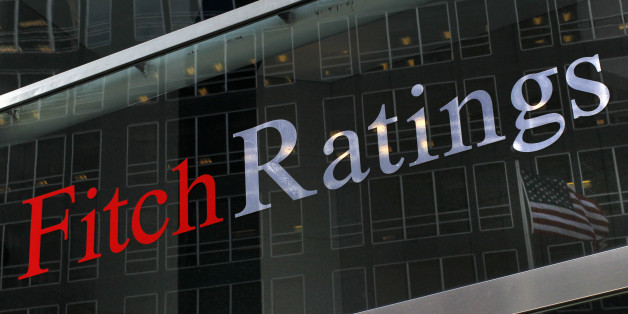 A flag is reflected on the window of the Fitch Ratings headquarters in New York February 6, 2013. REUTERS/Brendan McDermid (UNITED STATES - Tags: BUSINESS)