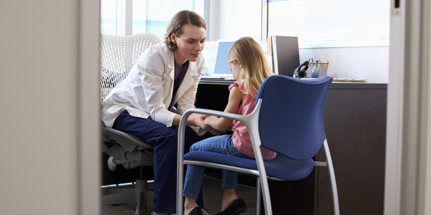 Pediatrician Talking To Unhappy Child In Hospital