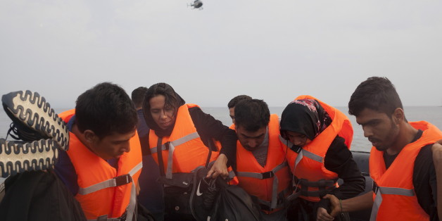 A Frontex helicopter flies over Syrian refugees that arrived on an overcrowded dinghy on the Greek island of Lesbos after crossing a part of the Aegean Sea from the Turkish coast, September 28, 2015. A record number of at least 430,000 refugees and migrants have taken rickety boats across the Mediterranean to Europe this year, 309,000 via Greece, according to International Organization for Migration figures. REUTERS/Dimitris Michalakis