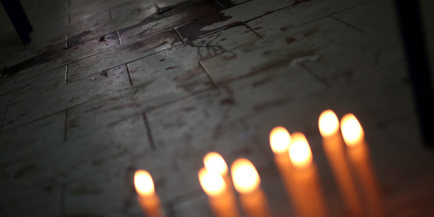 Candles are seen in front of the bloodstains of Rodrigo Quintana, who was killed last night by a rubber bullet fired by the police in the headquarters of the Liberal Party, after clashes in Asuncion, Paraguay, April 1, 2017. REUTERS/Marcos Brindicci