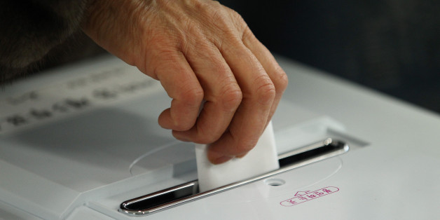 A woman casts her ballot for the presidential election at a polling station in Seoul, South Korea, on Wednesday, Dec. 19, 2012. South Koreans go to the polls today to choose either a dictator's daughter or a one-time dissident as president, both of whom pledge to reverse slowing growth, a widening income gap and deteriorating North Korea ties. Photographer: SeongJoon Cho/Bloomberg via Getty Images