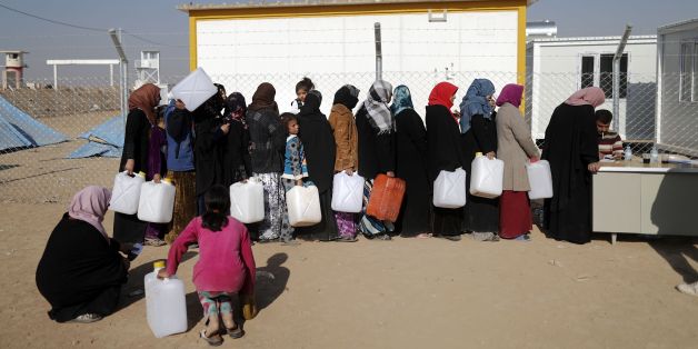 Internally displaced Iraqis, who fled the ongoing figthing between Islamic State (IS) group jihadists and government forces around Mosul, queue to fill containers with fuel for heating and cooking on November 28, 2016 at al-Khazer refugee camp.Some 70,000 civilians have fled the violence since Iraqi forces started the offensive to retake Mosul last month. / AFP / THOMAS COEX (Photo credit should read THOMAS COEX/AFP/Getty Images)