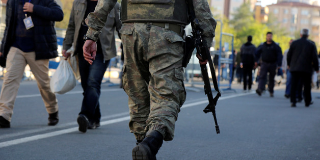 A soldier makes his way outside a polling station as election officials carry bags full of ballots following a voting procedure for a referendum in the Kurdish-dominated southeastern city of Diyarbakir, Turkey, April 16, 2017. REUTERS/Sertac Kayar TPX IMAGES OF THE DAY