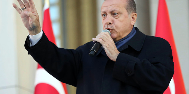 Turkish president Recep Tayyip Erdogan flashes a four finger sign called 'the rabia sign' as he delivers a speech to his supporters at the Presidential Palace in Ankara, April 17, 2017 following the results in a nationwide referendum that will determine Turkey's future destiny.Erdogan on April 17 said Turkey could hold a referendum on its long-stalled EU membership bid after Turks voted to approve expanding the president's powers in a plebiscite. Narrowly won by President Recep Tayyip Erdogan, t