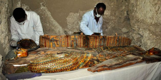 Members of an Egyptian archaeological team work on a wooden coffin discovered in a 3,500-year-old tomb in the Draa Abul Nagaa necropolis, near the southern Egyptian city of Luxor, on April 18, 2017.Egyptian archaeologists have discovered six mummies, colourful wooden coffins and more than 1,000 funerary statues in the 3,500-year-old tomb, the antiquities ministry said. / AFP PHOTO / STRINGER (Photo credit should read STRINGER/AFP/Getty Images)