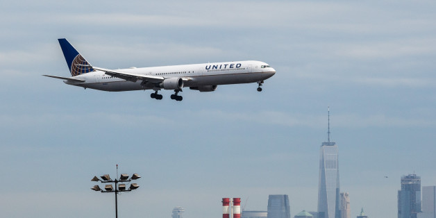 A United Continental Holdings Inc. airplane prepares for landing as the New York City skyline stands in the background at Newark Liberty International Airport (EWR) in Newark, New Jersey, U.S., on Wednesday, April 12, 2017. United Airlines is under fire for forcibly removing a passenger from a plane in Chicago shortly before departure to make room for company employees, an incident which demonstrates how airline bumping can quickly veer into confrontation. Photographer: Timothy Fadek/Bloomberg