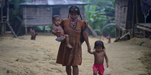 An Embera indigenous woman walks with her children in Puesto Indio, a rural village in Alto Baudo, department of Choco, western Colombia, on January 25, 2017.
Despite the peace deal signed by the Colombian government and the FARC rebels, a turf war for control over drug trafficking routes in the isolated department of Choco continues to rage between the smaller ELN guerrilla group and the Autodefensas Gaitanistas de Colombia, a criminal gang that emerged after the paramilitary demobilization a decade ago. / AFP / LUIS ROBAYO / TO GO WITH AFP STORY BY ALINA DIESTE (Photo credit should read LUIS ROBAYO/AFP/Getty Images)