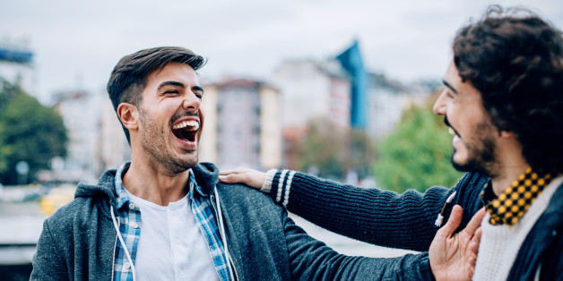 Smiling young men talking outdoors