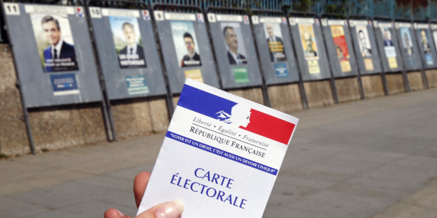 PARIS, FRANCE - APRIL 20: In this photo illustration, a French voter registration card is seen in front of official campaign posters for all eleven candidates for the 2017 French presidential elections posted outside a polling station on April 20, 2017 in Paris, France. French 2017 presidential election which will take place on April 23 and May 07, 2017. (Photo Illustration by Chesnot/Getty Images)