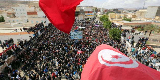 Tunisians wave their national flag as they take part in a general strike against marginalization and to demand development and employment on April 11, 2017, in Tataouine, south of Tunisia. / AFP PHOTO / FATHI NASRI (Photo credit should read FATHI NASRI/AFP/Getty Images)