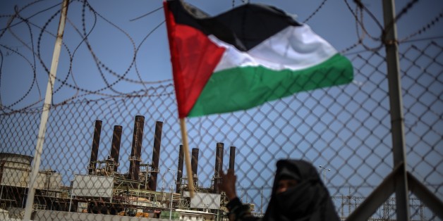 GAZA CITY, GAZA - APRIL 23 : A Palestinian woman waves Palestinian flag during a protest against the recent power cuts in front of power plant in Gaza City, Gaza on April 23, 2017. (Photo by Ali Jadallah/Anadolu Agency/Getty Images)