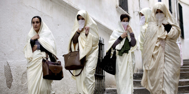 Group of women wearing haiks, long white embroidered gowns, Algerian women's traditional dress, walking in a lane of Algiers kasbah. (2015/11/21). (Photo by: Andia/UIG via Getty Images)
