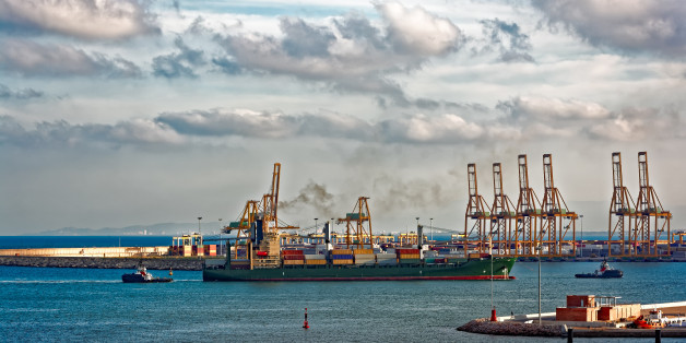 Containership arriving port Valencia with the assistance of two harbour tugs. Spain, Europe