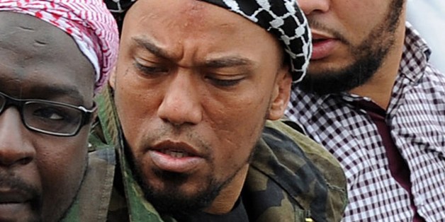Picture taken on May 5, 2012 shows former German rapper Denis Cuspert (C) among salafi in Bonn, Germany. Denis Mamadou Cuspert, who rapped under the name Deso Dogg but took on the name Abu Talha al-Almani in Syria, was initially reported to have been killed in a suicide attack Sunday in an eastern province but hours later some retracted the claim, saying he was still alive. AFP PHOTO /DPA/ HENNING KAISER GERMANY OUT (Photo credit should read HENNING KAISER/AFP/Getty Images)