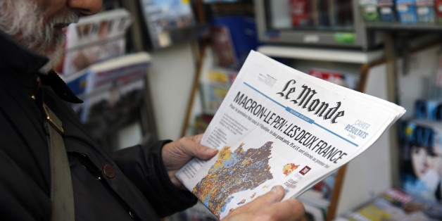 PARIS, FRANCE - APRIL 24: A man looks at the front page of the French newspaper 'Le Monde' a day after the first round of the French Presidential election on April 24, 2017 in Paris, France. Macron topped April 23's first round with 23.7 percent and National Front (FN) leader Le Pen with 21.9 percent, according to near-final results from the interior ministry. (Photo by Chesnot/Getty Images)