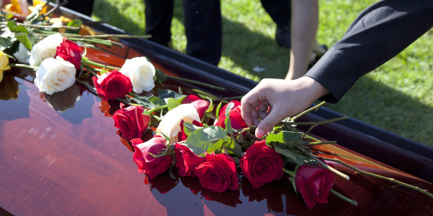 shot of roses and flowers on top of coffin