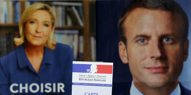 PARIS, FRANCE - MAY 05: In this photo illustration, a French voter registration card is seen in front of official campaign posters of candidates in the French presidential election, French National Front (FN) political party leader, Marine Le Pen (L) and President of the political movement 'En Marche !' (Onwards !) Emmanuel Macron (R) on May 05, 2017 in Paris, France,. Le Pen and Macron arrived in the lead positions in the first round of the presidential elections. France will hold the second round on May 07, 2017. (Photo illustration by Chesnot/Getty Images)