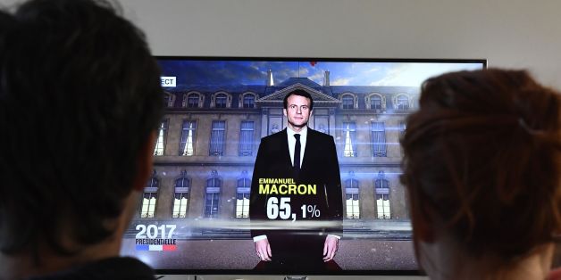 A couple watch a TV screen displaying French President elected Emmanuel Macron with an estimated score of more than 65 precent, on May 7, 2017 in Hede-Bazouges, western France.
Pro-European centrist Emmanuel Macron won France's landmark presidential election, first estimates showed today, heading off a fierce challenge from the far-right in a pivotal vote for the future of the divided country and Europe. / AFP PHOTO / DAMIEN MEYER (Photo credit should read DAMIEN MEYER/AFP/Getty Images)