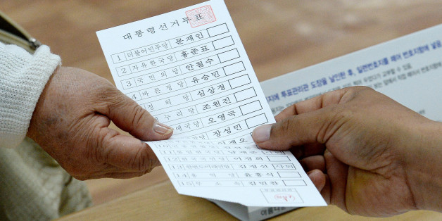 제19대 대통령선거일인 9일 오전 서울 송파문화원에 마련된 잠실7동 제1투표소에서 한 유권자가 투표를 하기위해 투표용지를 받고 있다.