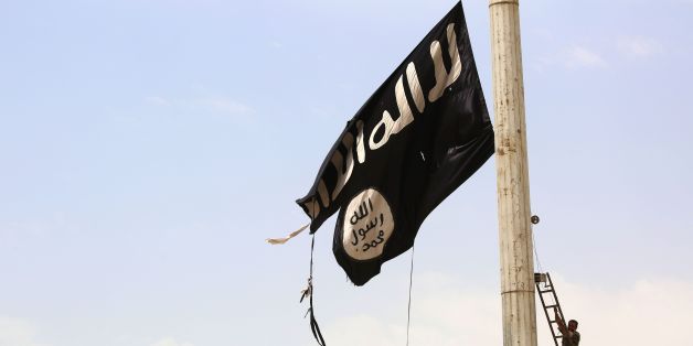 TOPSHOT - A member of the US-backed Syrian Democratic Forces (SDF), made up of an alliance of Arab and Kurdish fighters, removes an Islamic State group flag in the town of Tabqa, about 55 kilometres (35 miles) west of Raqa city, on April 30, 2017, as they advance in their battle for the group's de facto capital.
US-backed fighters have captured 80 percent of Syria's Tabqa from the Islamic State group, a monitor said on May 1, a week after they first entered the town. / AFP PHOTO / DELIL SOULEIMAN (Photo credit should read DELIL SOULEIMAN/AFP/Getty Images)