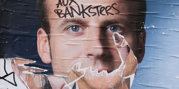A picture taken on May 8, 2017 shows a vandalised electoral campaign poster of French president-elect Emmanuel Macron in Paris, reading 'France to the banksters'. / AFP PHOTO / JOEL SAGET (Photo credit should read JOEL SAGET/AFP/Getty Images)