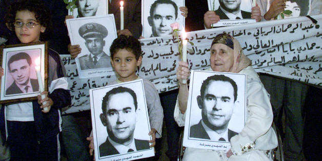 Moroccans hold portraits of former Moroccan opposition leader Mehdi BenBarka during a candle-lit gathering in Rabat late October 29, 2002. BenBarka, the charismatic exiled leftist leader, was seized in October1965 in front of the Lippe cafe in the Latin Quarter of Paris, but whathappened to him after remains the source of much conjecture.REUTERS/Joelle VassortJES/JDP
